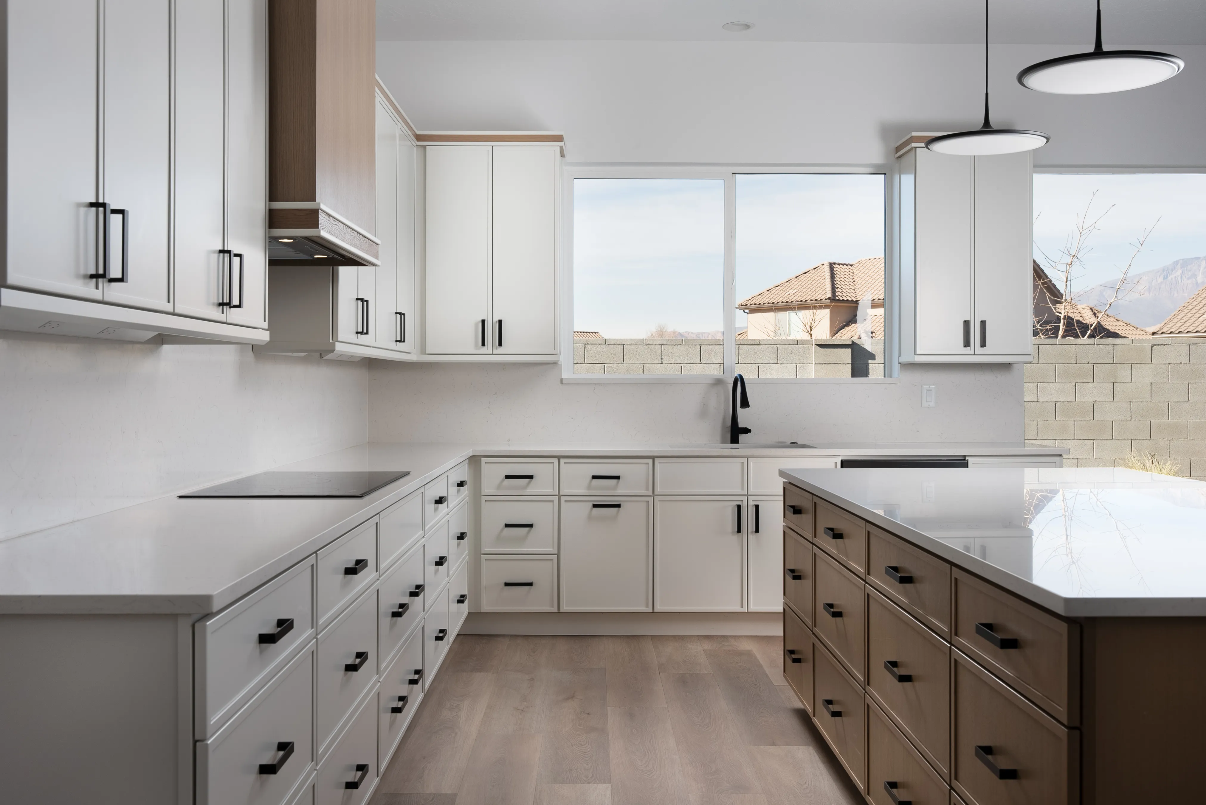 White Shaker kitchen we installed at Dixie Springs — black appliances and a wood-look island