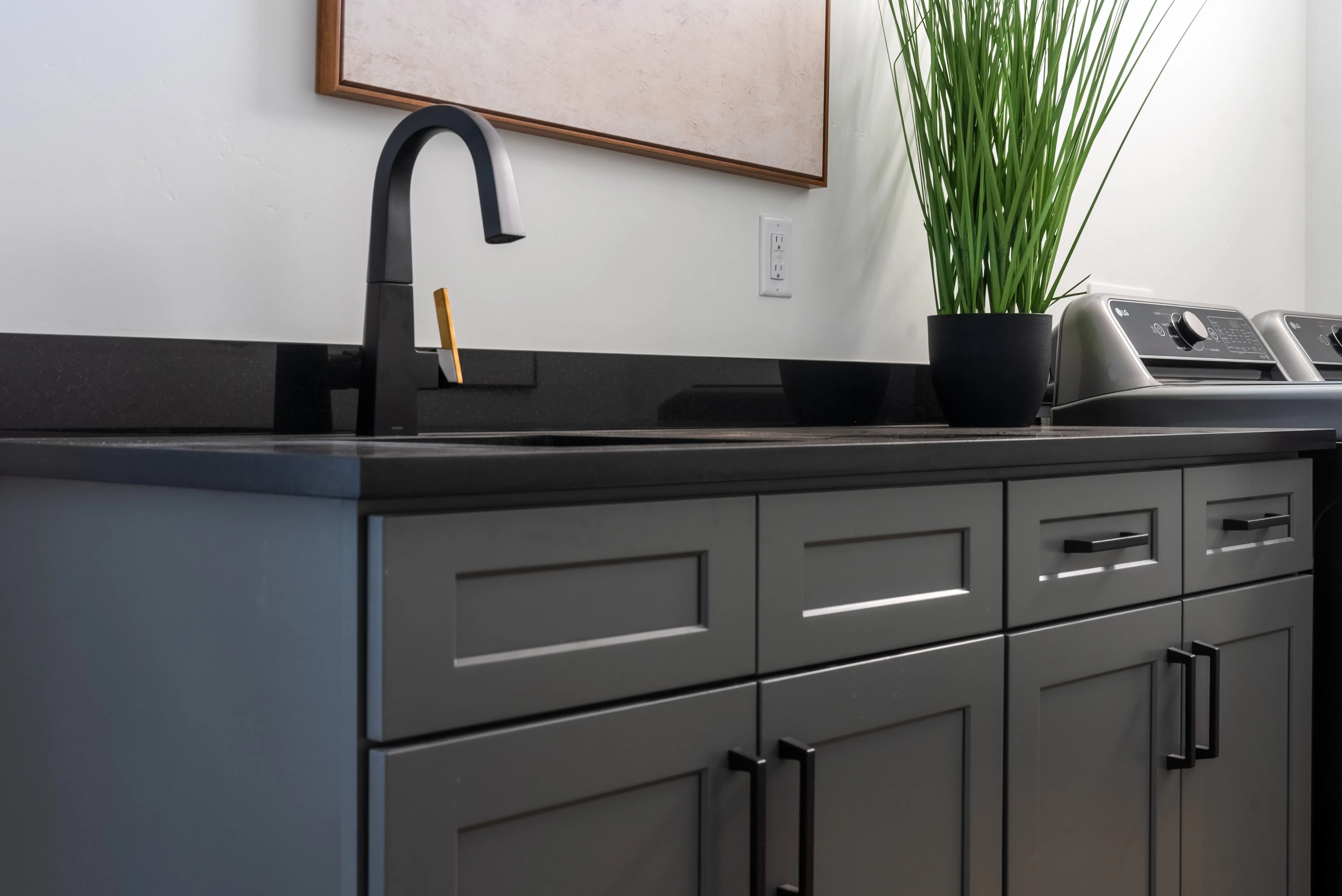 Charcoal laundry cabinets with a black faucet from our Pecan Valley build