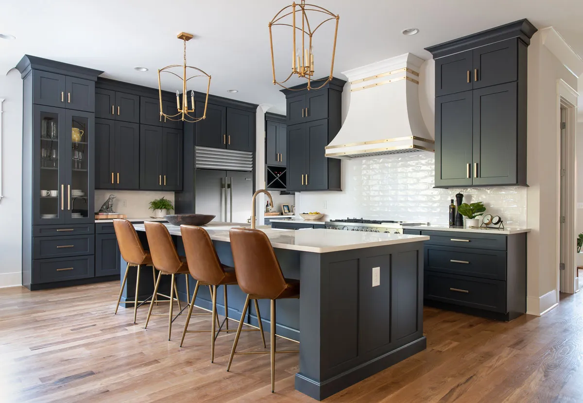 Navy Shaker cabinets with brass hardware and a white hood — the Legacy line
