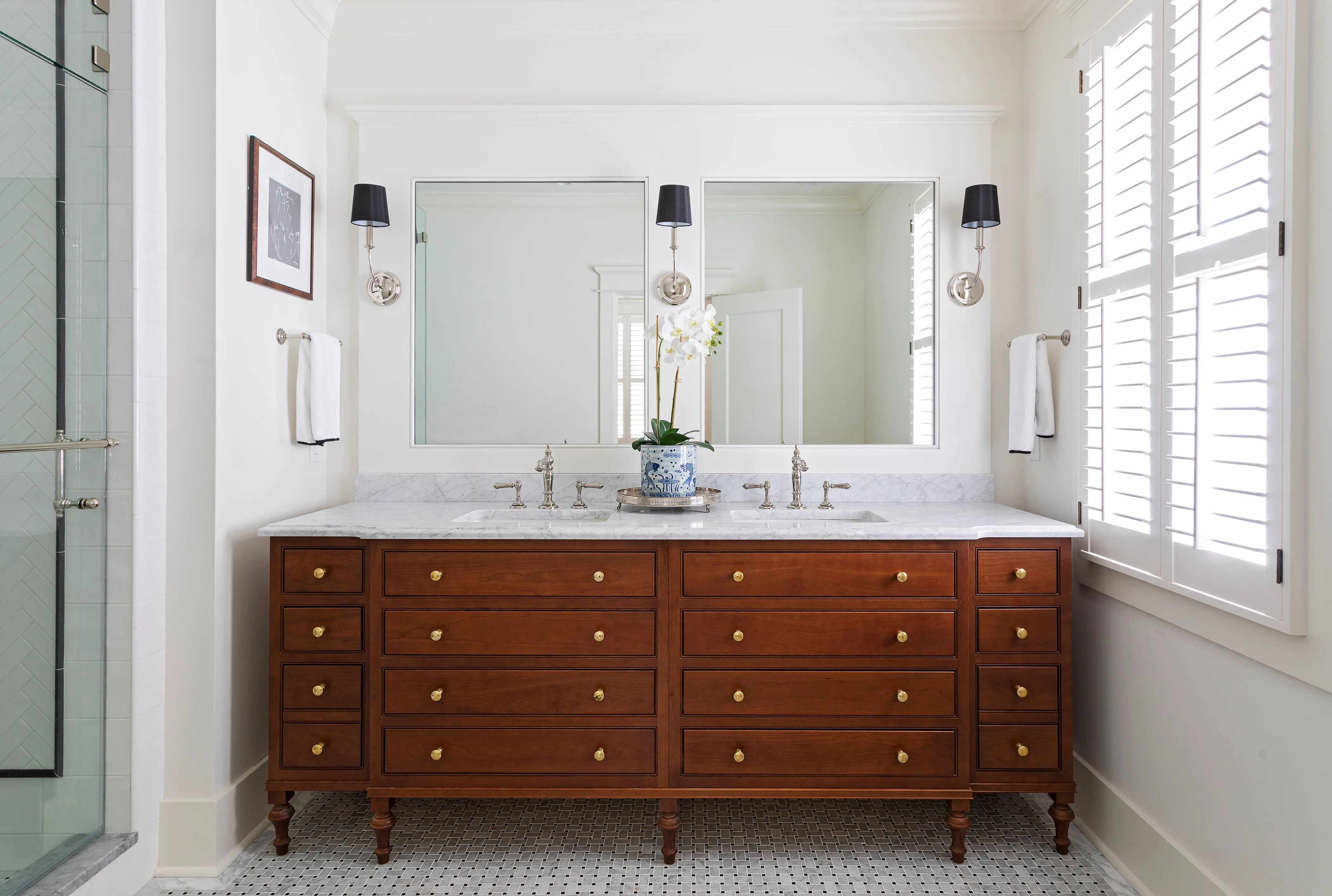 Cherry furniture-style double vanity with turned legs, brass knobs, and a marble top