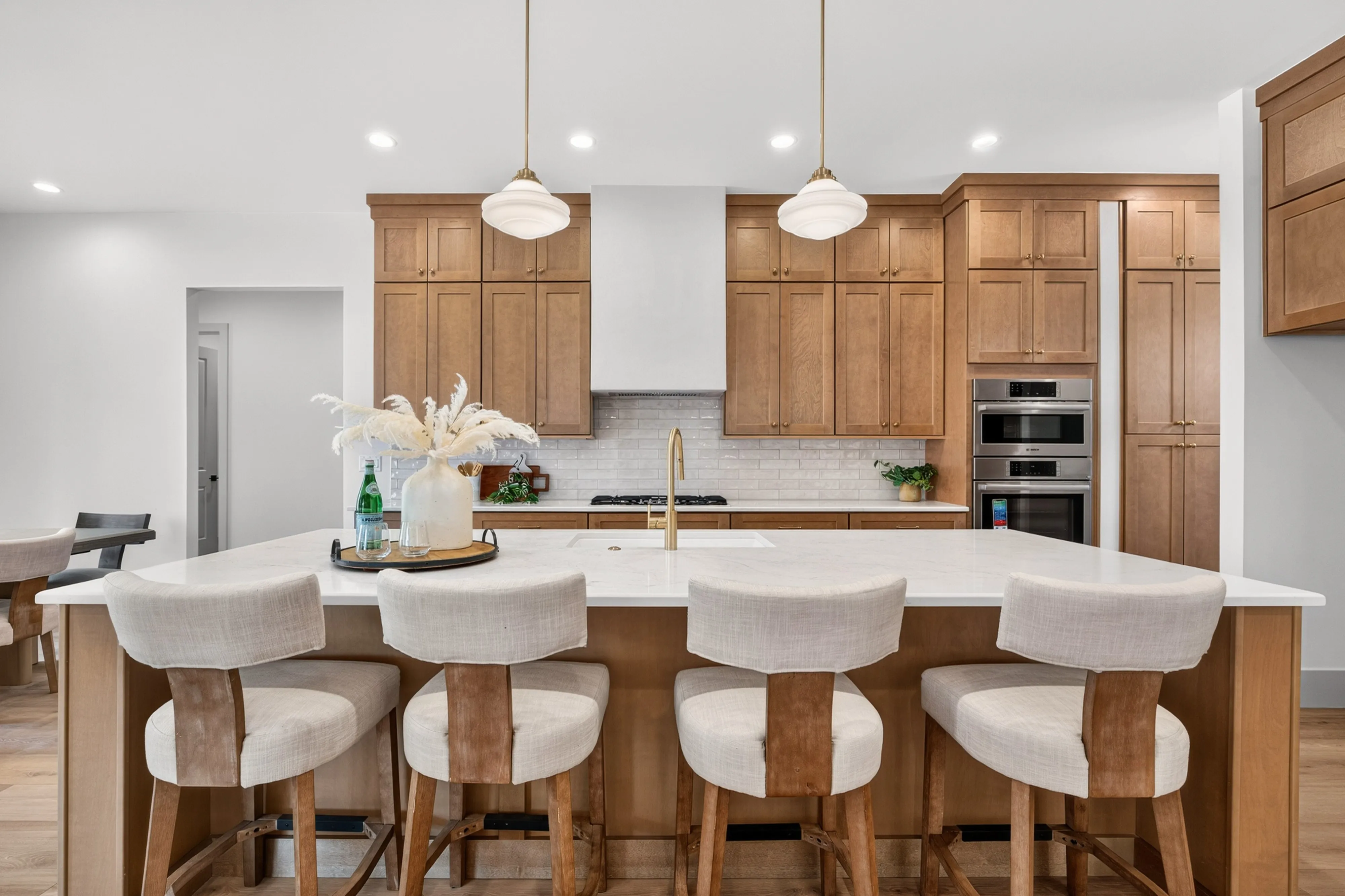 A Genesis kitchen in honey-oak Lux Shaker at 1927 Rimview Drive — custom hood and a white quartz island