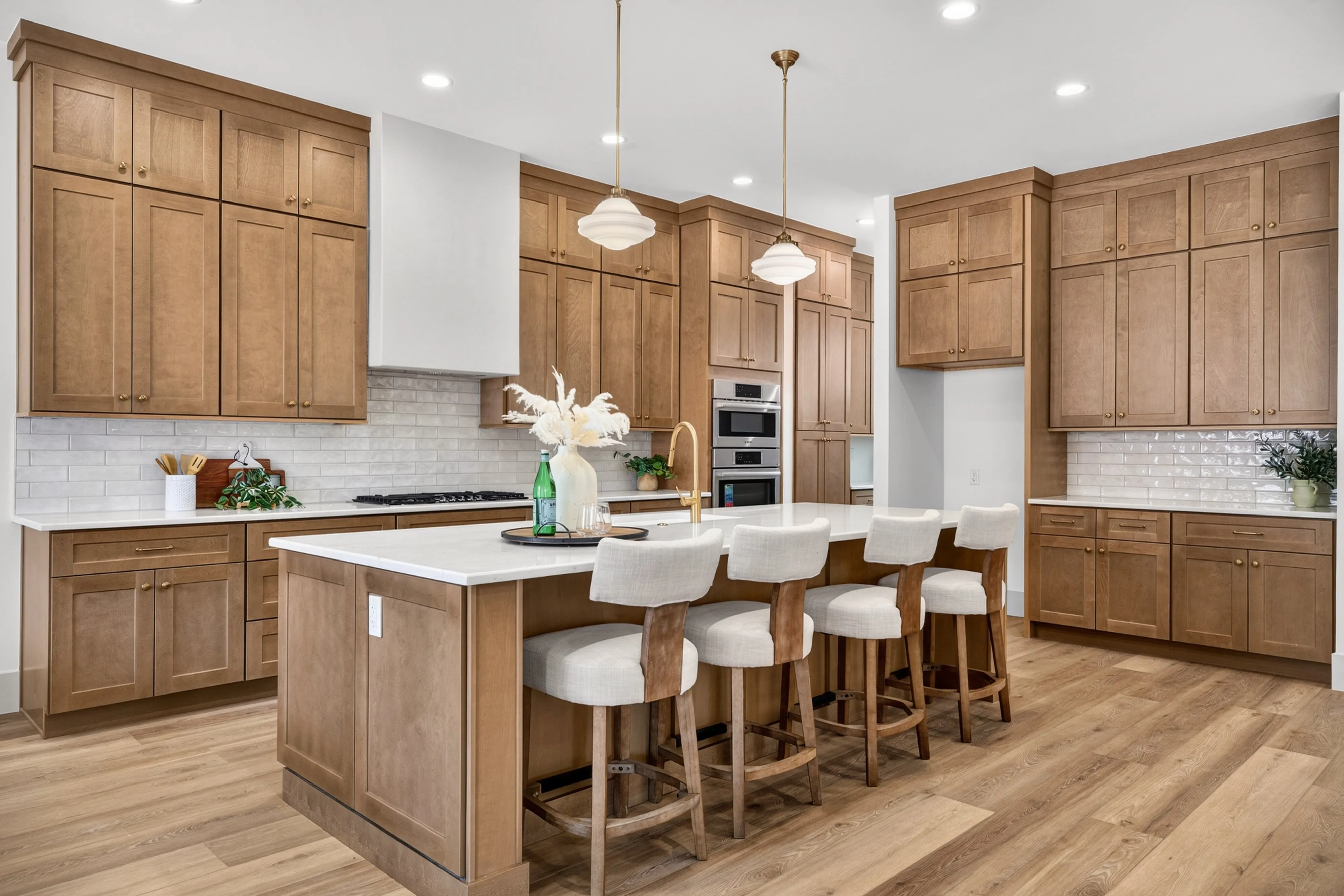 A honey-oak Genesis kitchen from our Rimview project — quartz island with seating