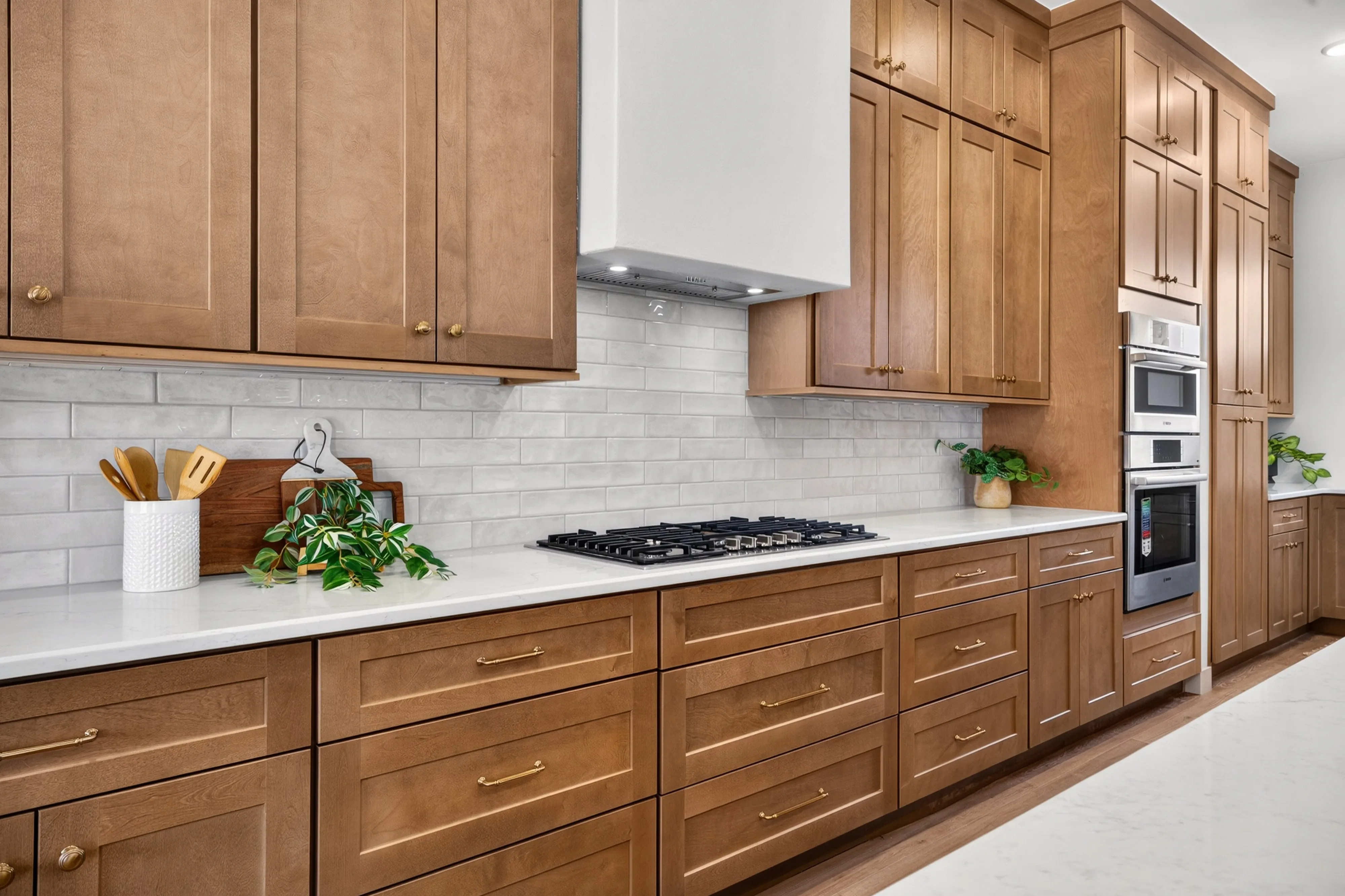 Oak Lux Shaker range wall with white subway tile and quartz counters, from our Rimview project